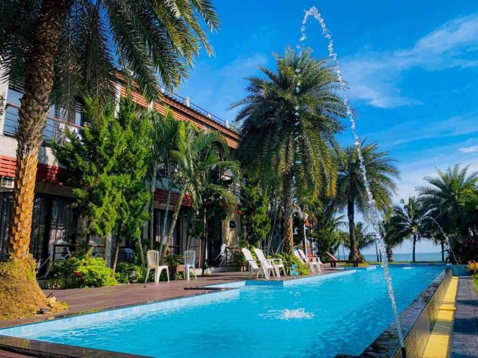 a swimming pool in a resort with palm trees at Windy Seaview Resort in Chao Lao Beach