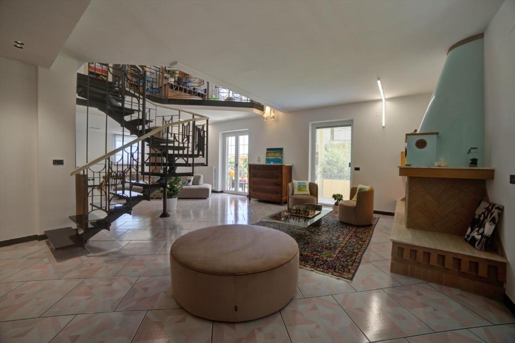 ein großes Wohnzimmer mit einer Treppe und einem Stuhl in der Unterkunft Villa Alba in Petacciato