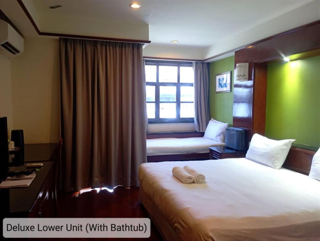 a hotel room with a bed and a window at Alpine LXPD Water Chalet in Port Dickson