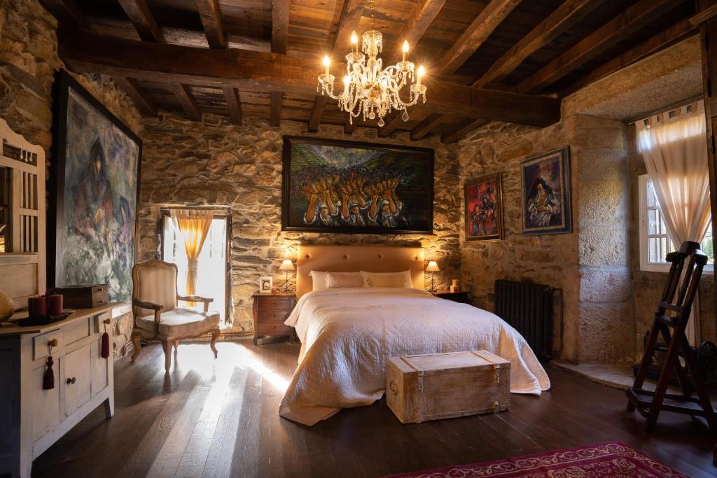 a bedroom with a large bed and a chandelier at Casa Muíñovedro in Chantada