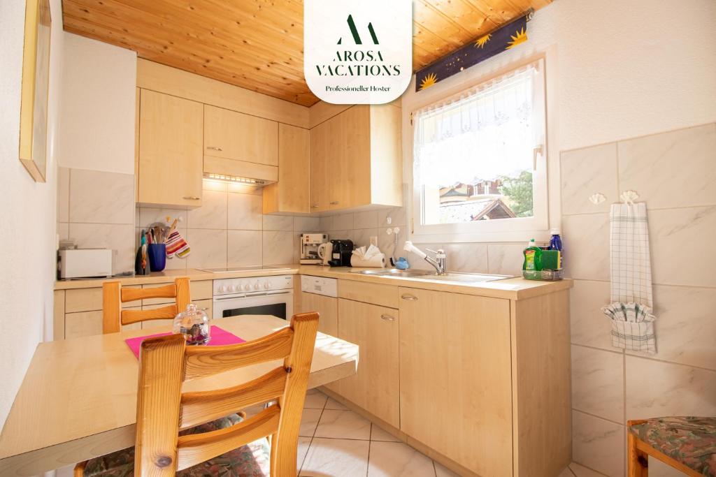 a small kitchen with a table and a sink at Haus Padrun, Apartment nr.6 in Arosa