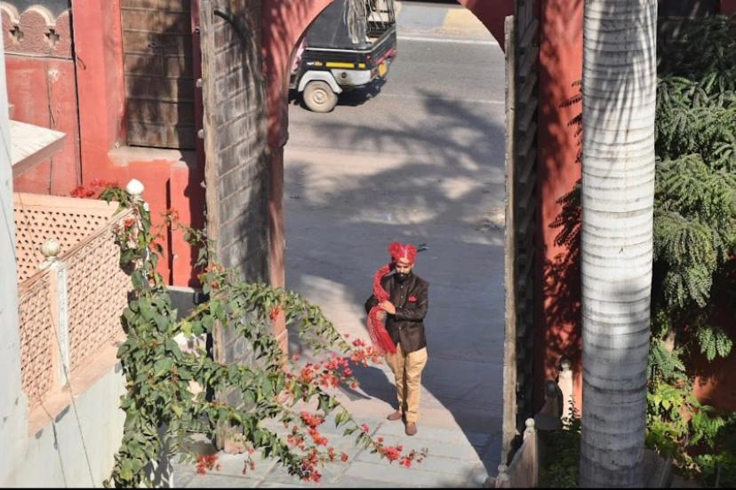 a man walking down a street with a red head at Kishan Palace-A heritage Hotel in Bikaner