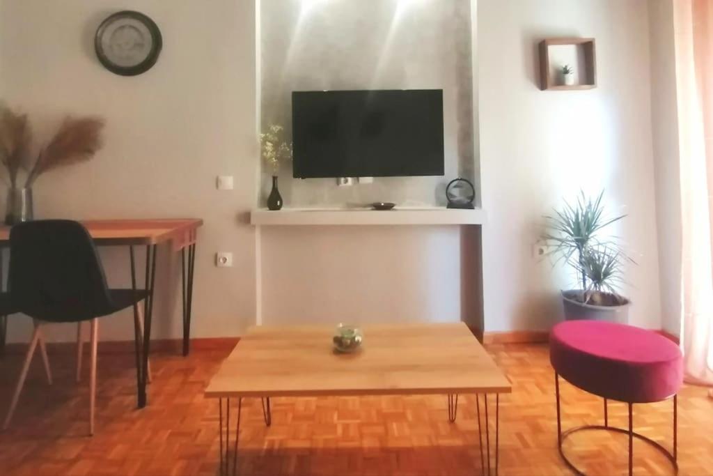 a living room with a table and a tv at City Center Beauty in Serres
