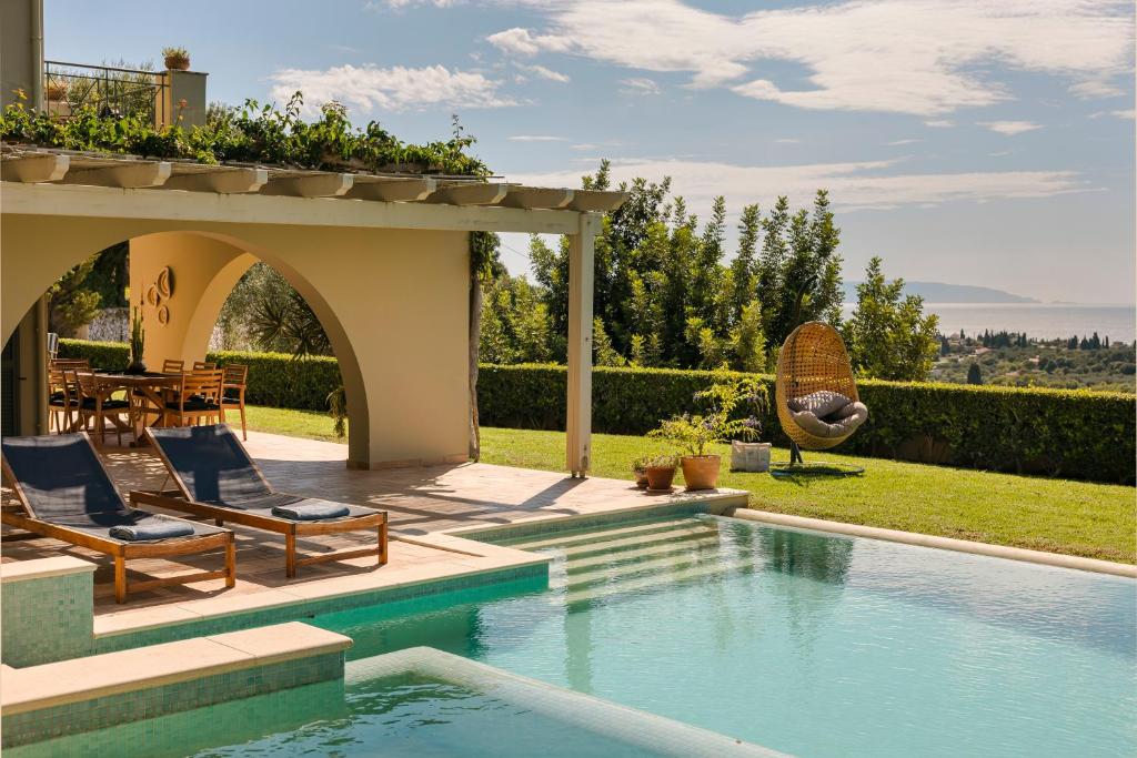 a house with a swimming pool and a patio with chairs at Sarlata Villas in Sarlata