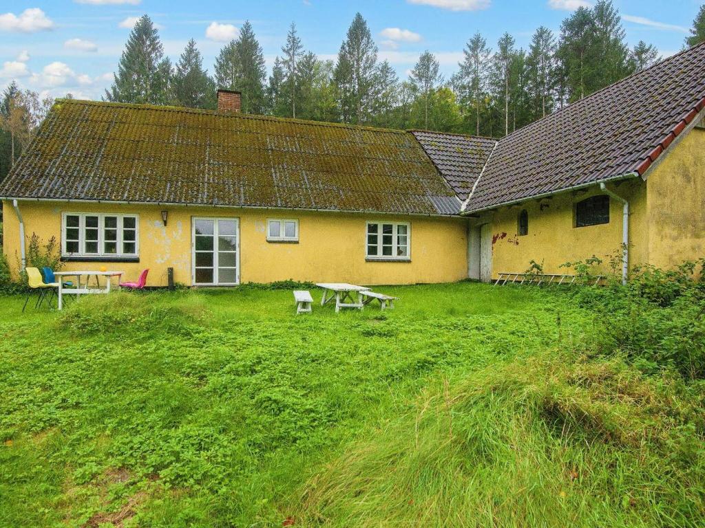 uma casa amarela com uma mesa de piquenique em frente em 5 person holiday home in Skanderborg em Skanderborg