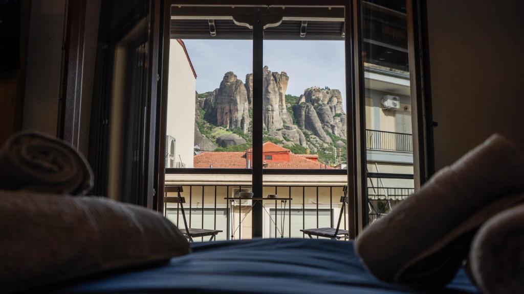 a bedroom with a view of a mountain from a window at ORIENTE SUITE APARTMENT in Kalabaka