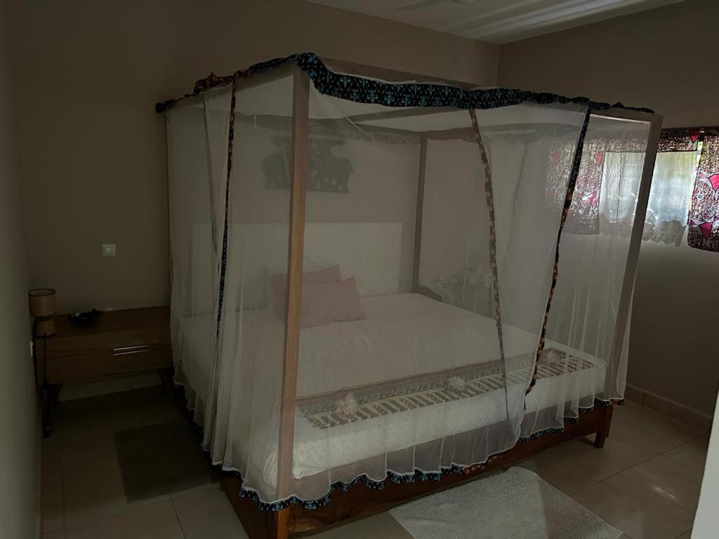 a bed with a canopy in a room at POMBO KUNDA in Sanyang