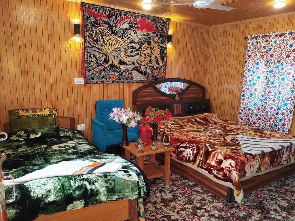 シュリーナガルにあるH.B Holiday homeのベッドルーム1室(ベッド2台付)が備わります。壁には絵画が飾られています。