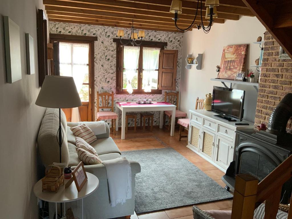 een woonkamer met een bank, een tv en een tafel bij La Casuca in Escalante