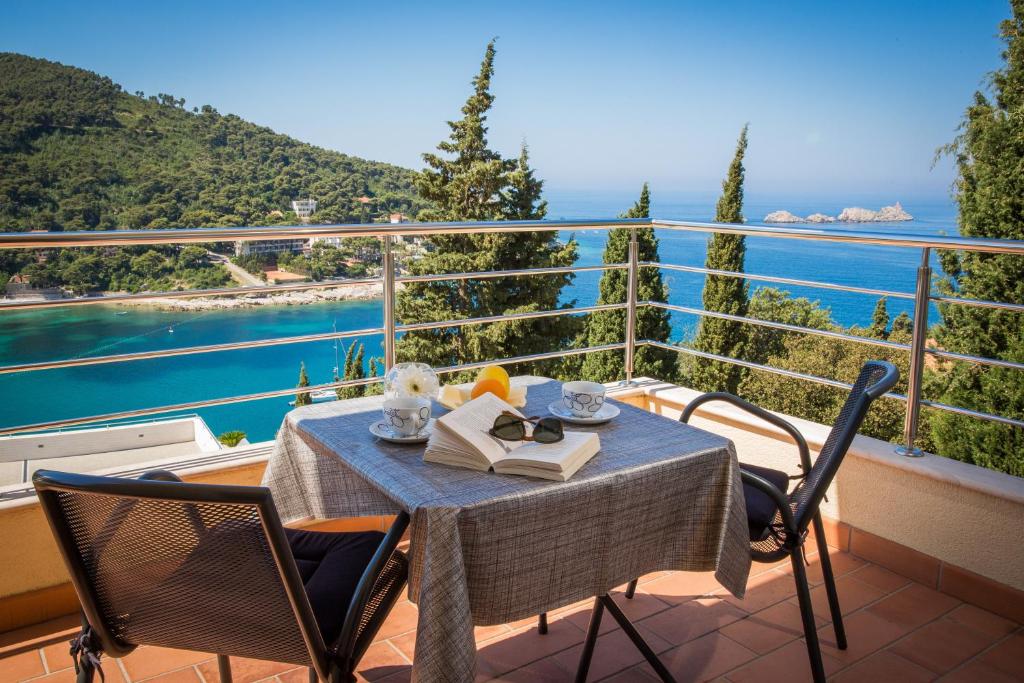 a table on a balcony with a view of the water at Apartment Vista 2 in Dubrovnik