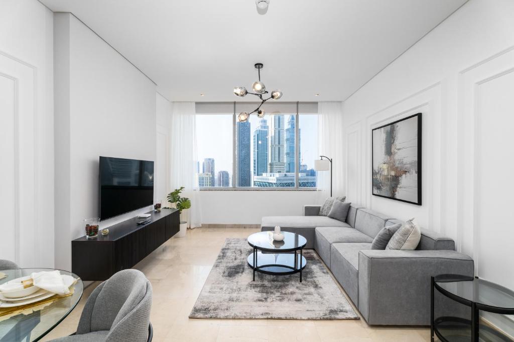 a living room with a couch and a table at Nasma Luxury Stays - Elegant 1BR With Stunning View of Park Avenue in Dubai