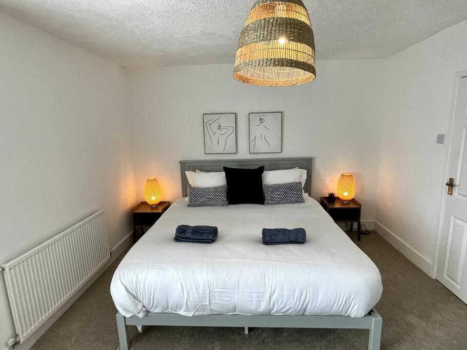 a bedroom with a bed with two blue towels on it at Charming Terrace Home, Nantwich -Near train station & Town in Nantwich