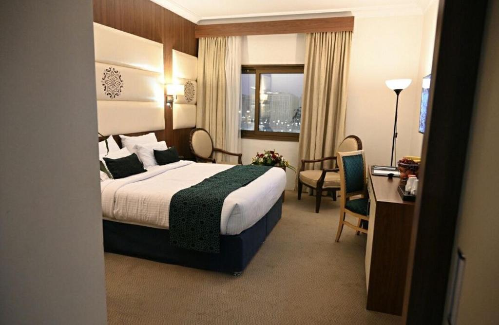 One Inn Hotel في المدينة المنورة: غرفة الفندق بسرير ومكتب وكرسي