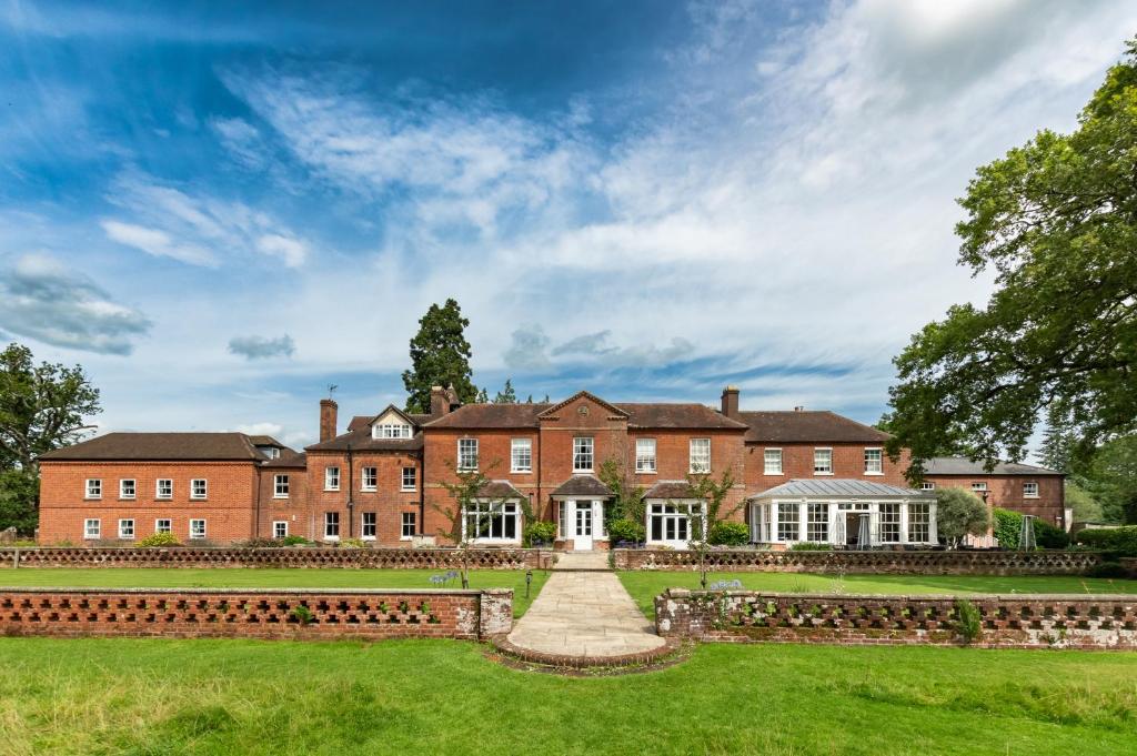 un grande edificio in mattoni rossi con un prato di Bartley Lodge Hotel a Lyndhurst