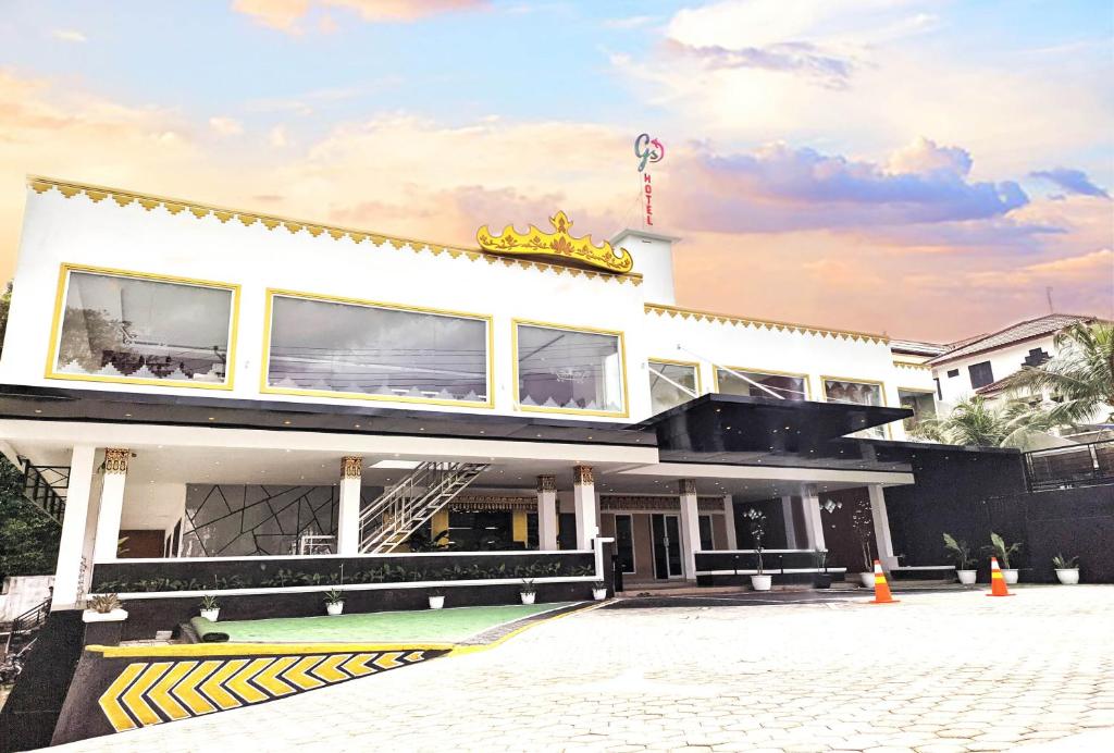 - un grand bâtiment blanc avec un panneau jaune dans l'établissement GS Lampung Culture Syariah, à Lampung