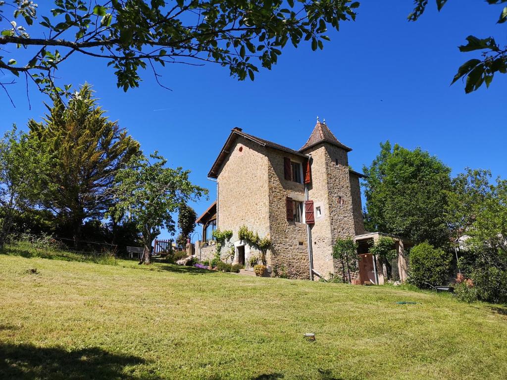 une ancienne maison en pierre sur un champ herbeux dans l'établissement Villa Thérèse, à Beaulieu-sur-Dordogne