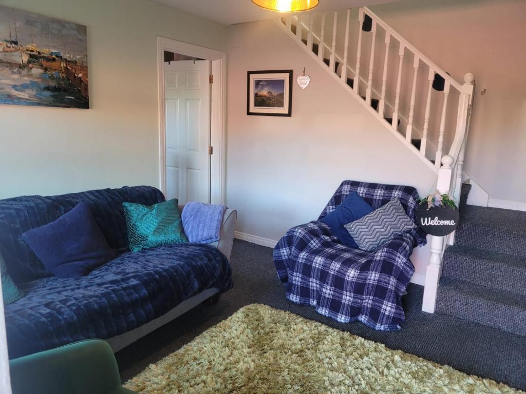 ein Wohnzimmer mit einem Sofa und einem Stuhl in der Unterkunft Lovely apartment @ the Old barn. in Kircubbin