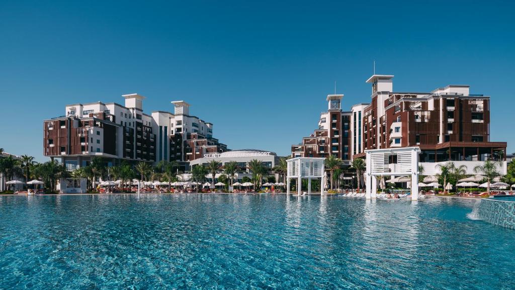 ein großes Schwimmbad in einer Stadt mit hohen Gebäuden in der Unterkunft Selectum Luxury Resort Belek in Belek