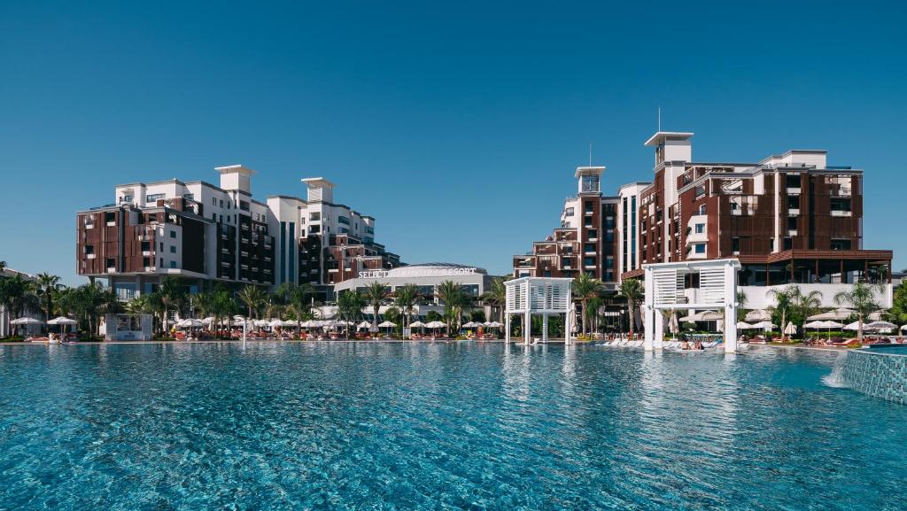 a large swimming pool in a city with tall buildings at Selectum Luxury Resort Belek in Belek