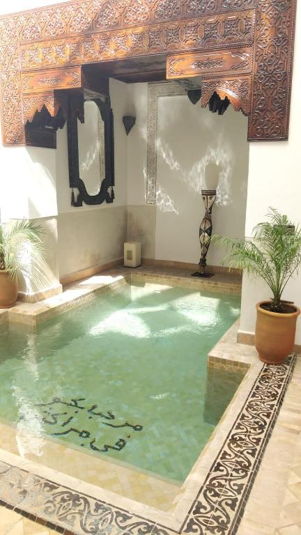 a large swimming pool in a building with a large pool at Ryad Petit Palmier in Marrakech