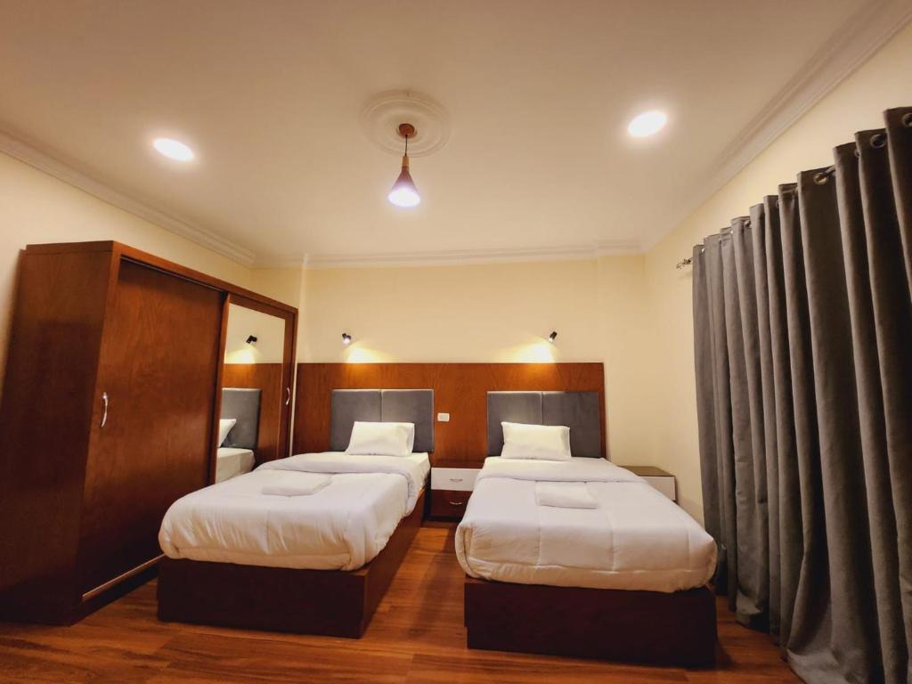 a hotel room with two beds and curtains at Wa set Luxor Apartment in Luxor
