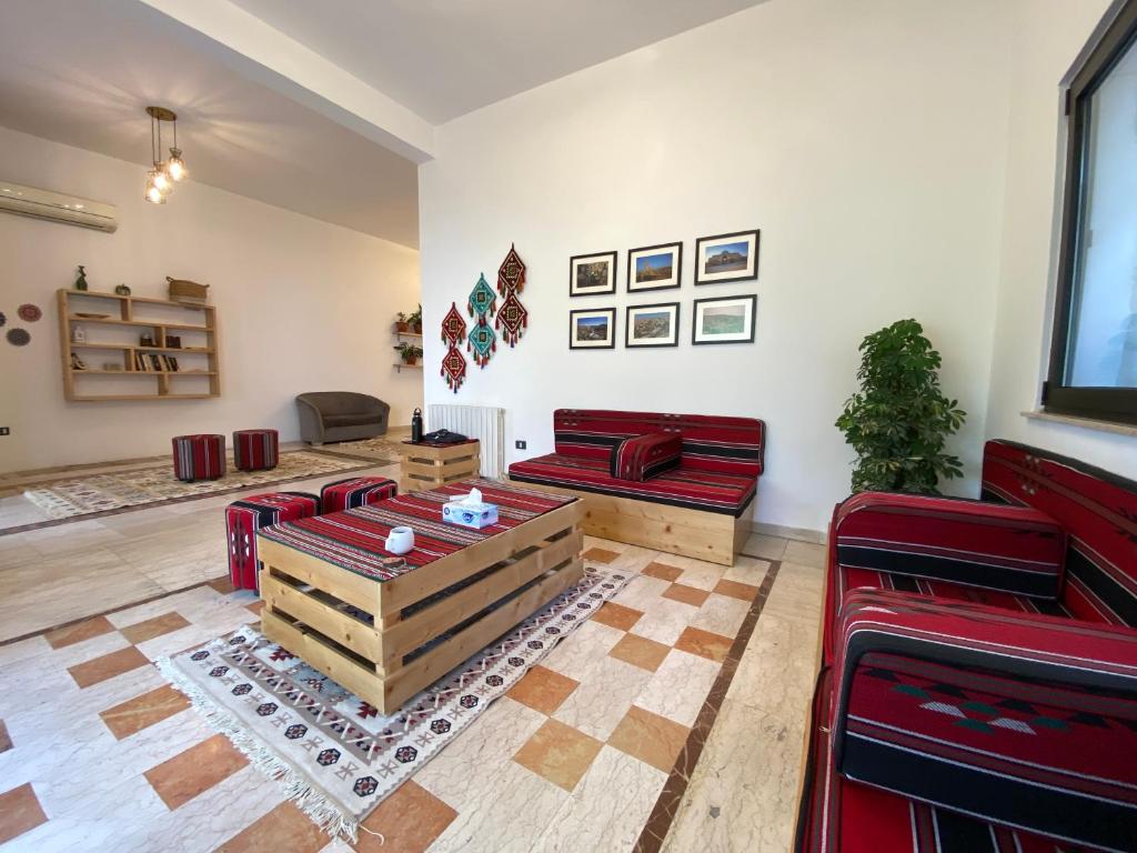 a living room with red chairs and a table at Lemon Tree Residence in Amman
