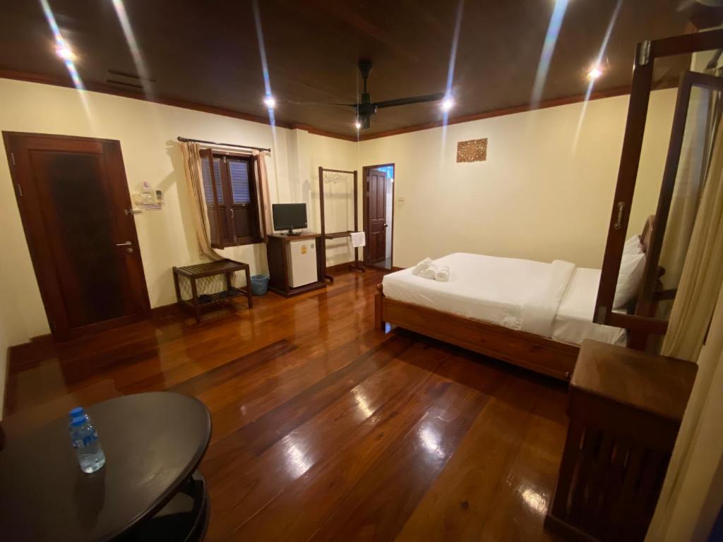 a room with a bed and a table in it at somvang khily guesthouse 宋旺吉利 酒店 in Luang Prabang