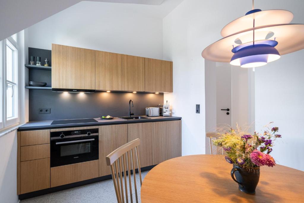 une cuisine avec une table en bois et un vase de fleurs dans l'établissement Apartment Blausand, à Ahrenshoop