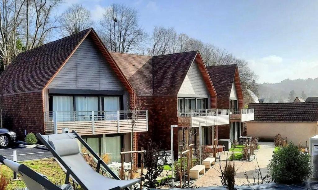 a brick house with a porch and a balcony at Appartement proche centre historique avec parking in Sarlat-la-Canéda