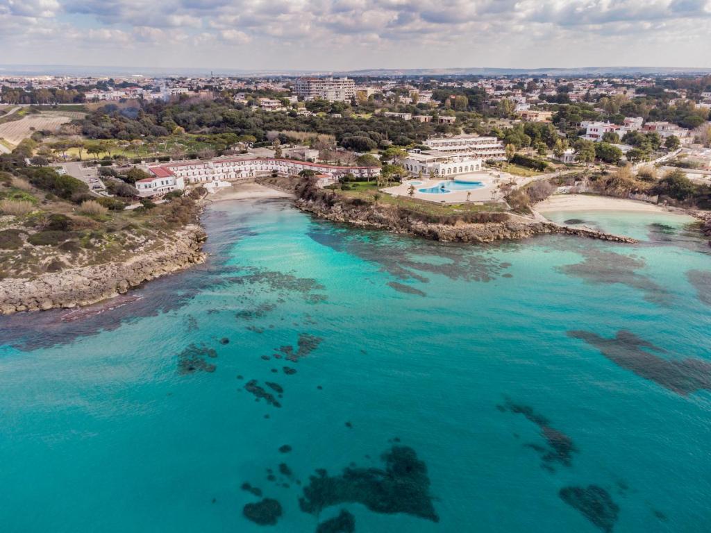 una vista aerea di una spiaggia con acqua blu di Mon Rêve Resort a Taranto