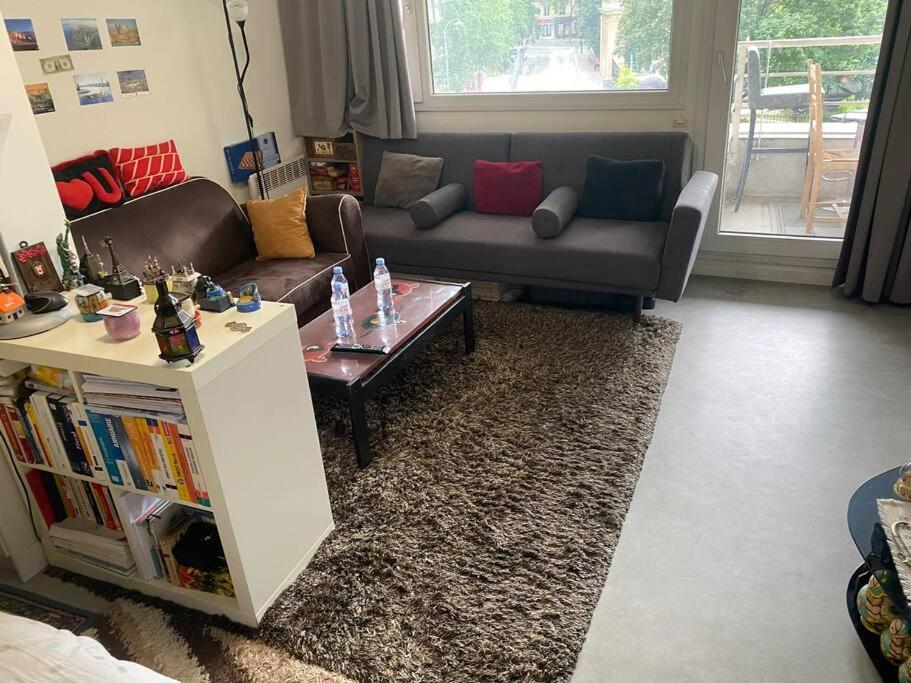 un salon avec un canapé et une table basse dans l'établissement Beau appart à balcon vue Tour Eiffel & parking, à Paris