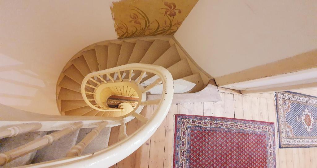 a spiral spiral staircase in a room with wooden floors at VIEUX LILLE Porte de Gand Bienvenue chez NESTYOU, Lille in Lille