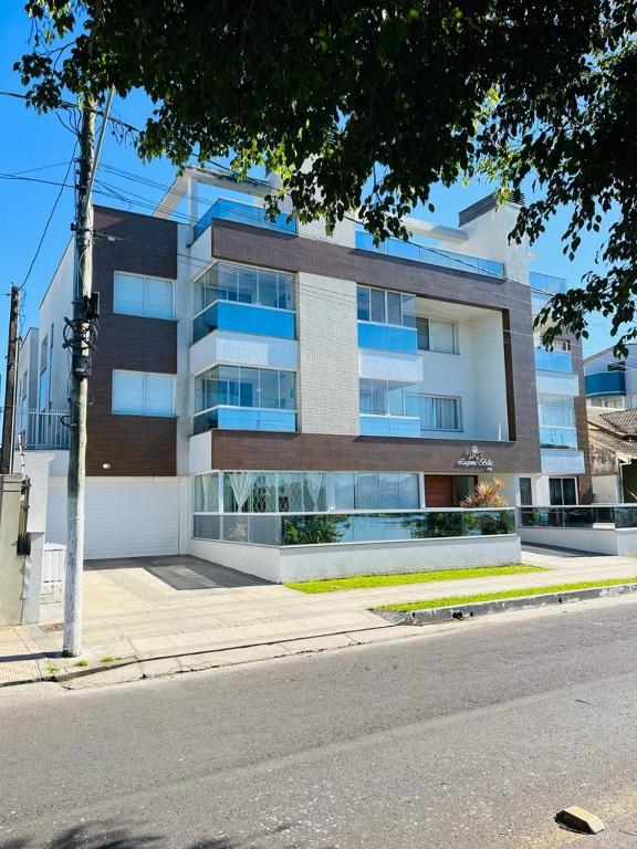 a large building on the side of a street at Apto duplex Lagoa do Violão in Torres