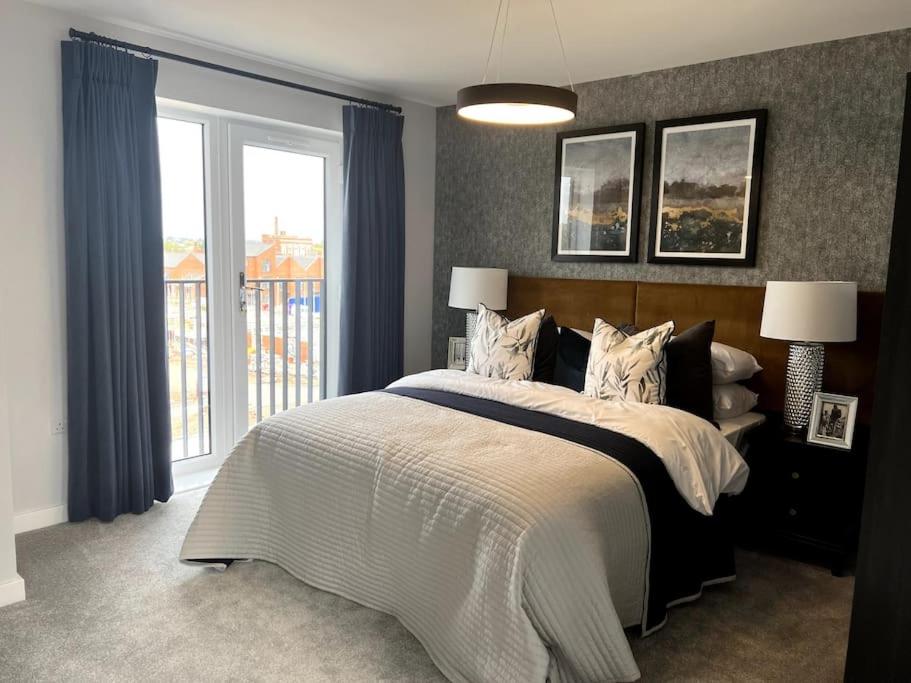 ein Schlafzimmer mit einem großen Bett und einem Fenster in der Unterkunft Waterside House in Leicester
