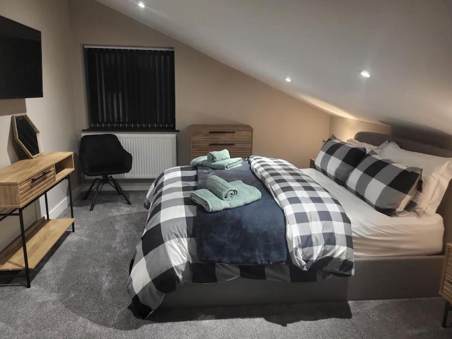 a bedroom with a black and white bed and a desk at Shylo - Down At The Dales in Barry