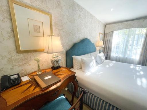 1 dormitorio con 1 cama y escritorio con teléfono en The Andros Boutique Hotel, en Ciudad del Cabo
