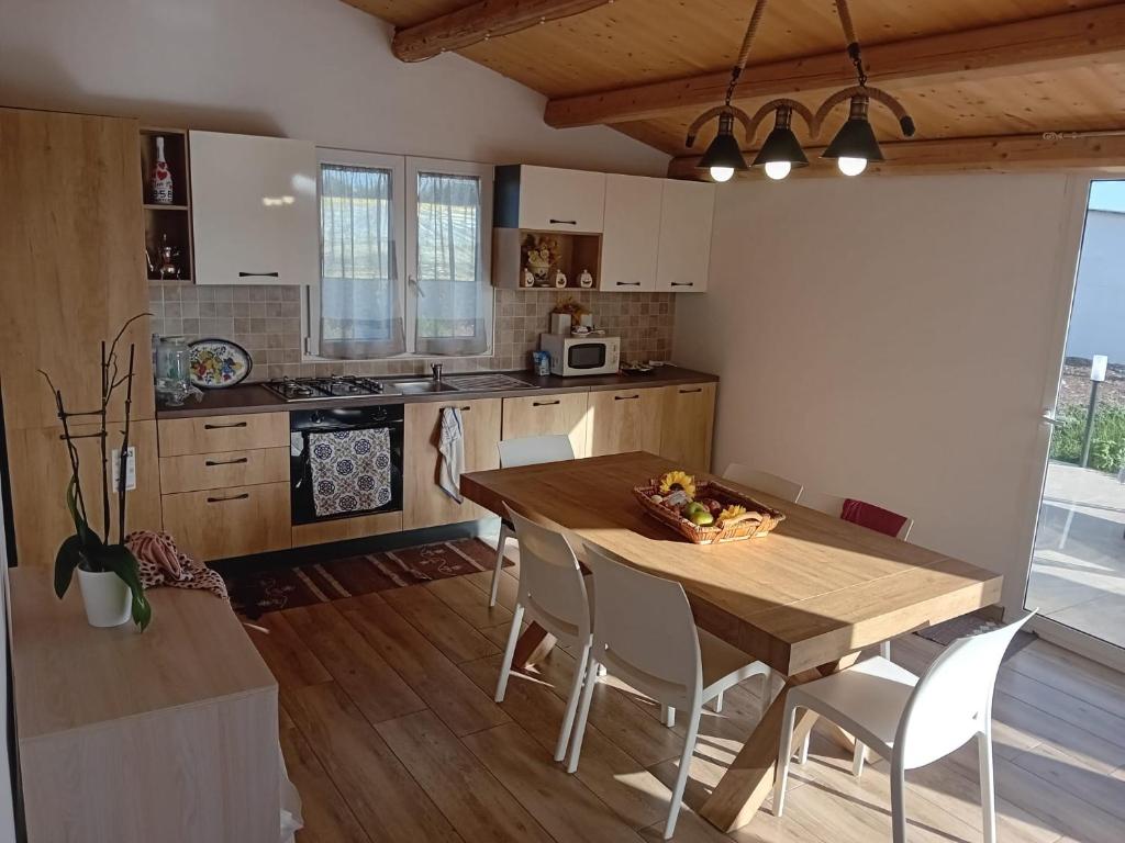 a kitchen with a wooden dining table and chairs at Casa del Contadino in Vittoria
