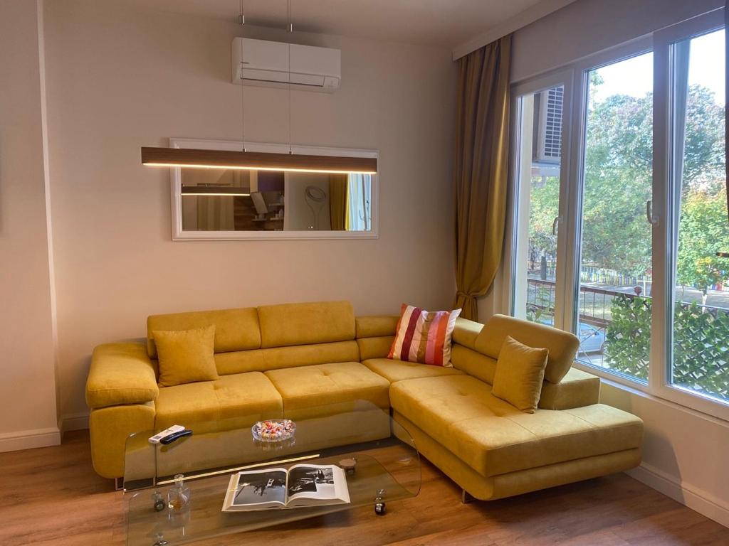 a living room with a yellow couch and a window at Casa Dell'Arte in Sofia