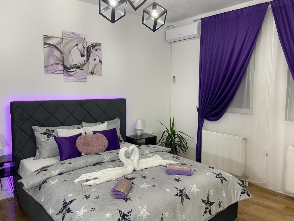um quarto com uma cama grande e cortinas roxas em GLAMUR APARTMANI Novi Sad em Novi Sad