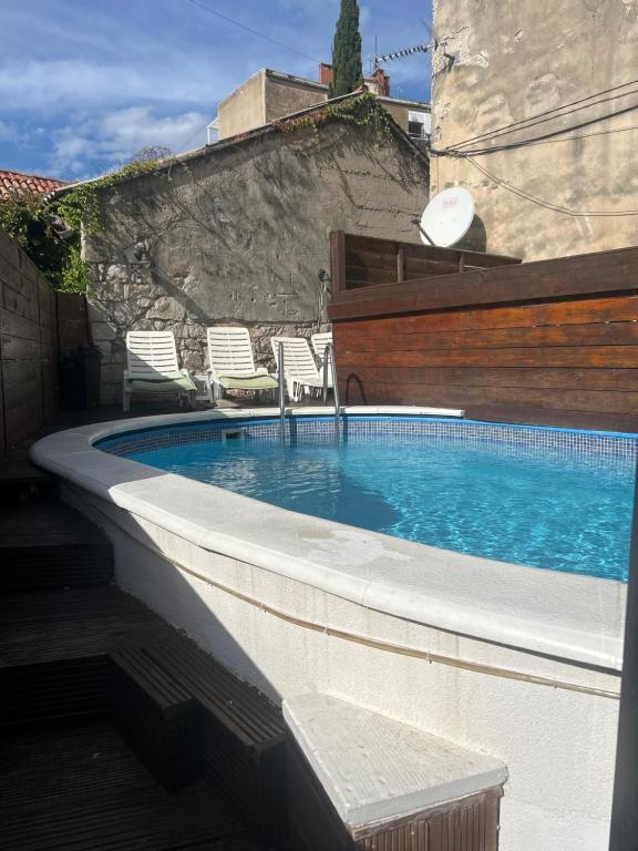 a swimming pool with chairs next to a building at Elena Rooms Split in Split