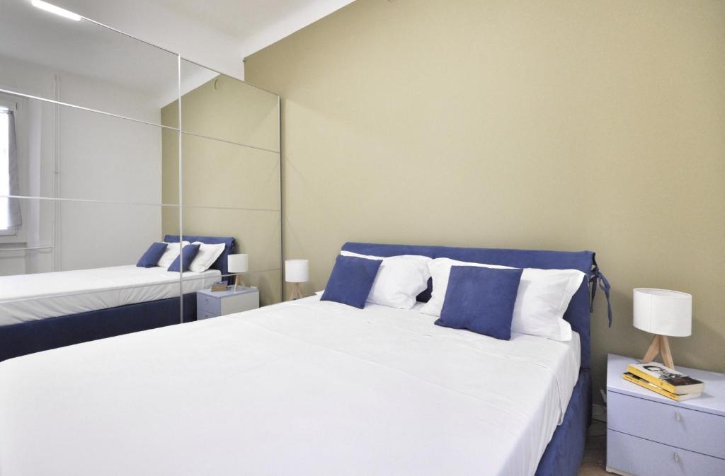 a bedroom with two beds with blue and white pillows at MARCONA 1 - City Centre Apt with Terrace in Milan