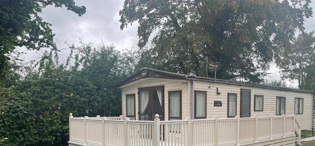 una pequeña casa blanca con una valla blanca en New Forest 2-Bed Premium Holiday Home New Milton, en New Milton