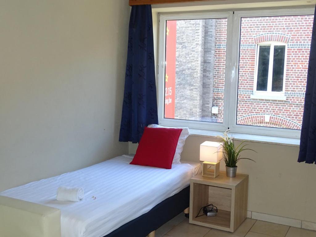 a small bed in a room with a window at Room in Apartment - Condo Gardens Leuven - Student Studio Single in Leuven