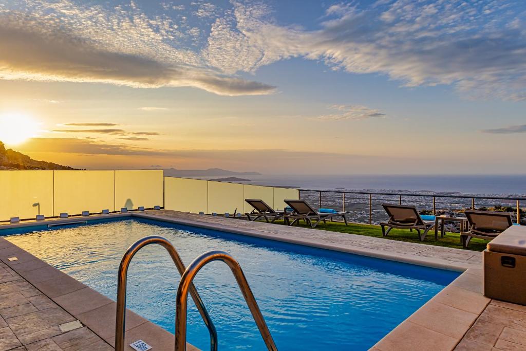 ハニア・タウンにあるVilla Mari Chania, with private ecologic pool and amazing view!の海に面した建物の上にあるスイミングプール