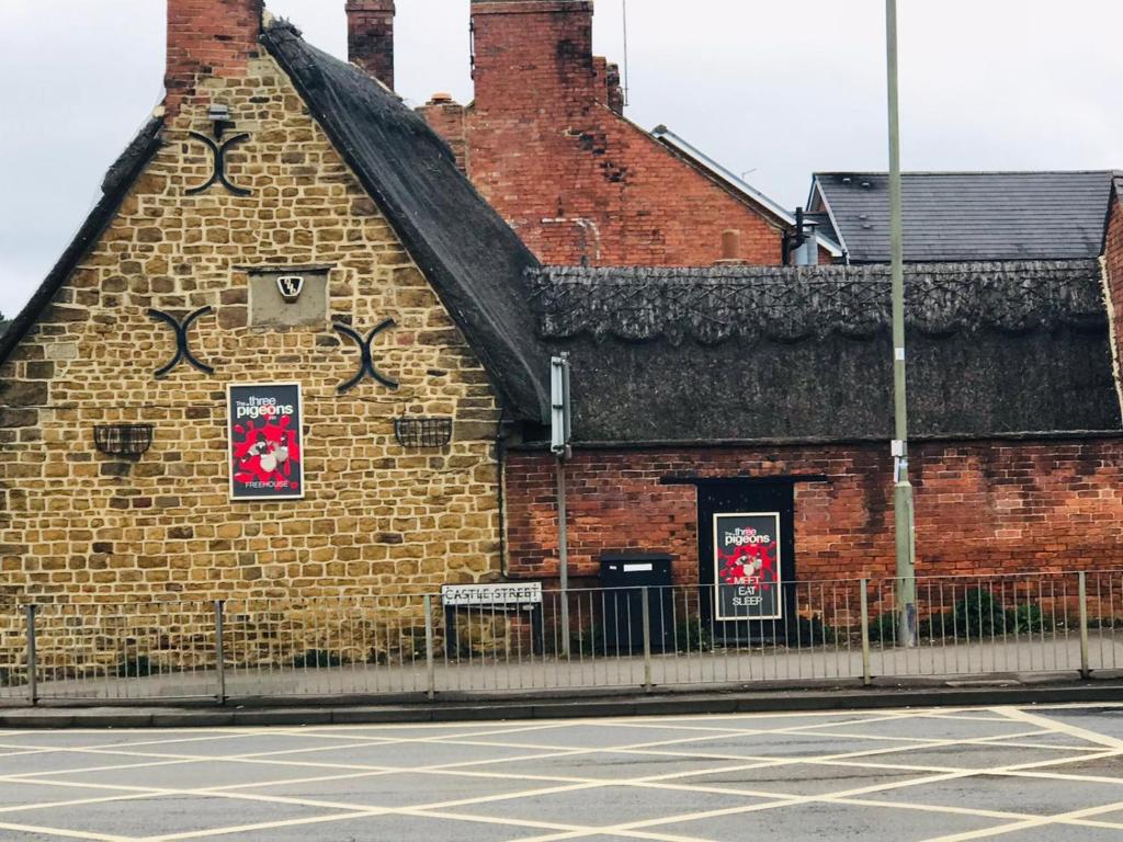 um edifício de tijolos com graffiti na lateral em The Three Pigeons Inn em Banbury