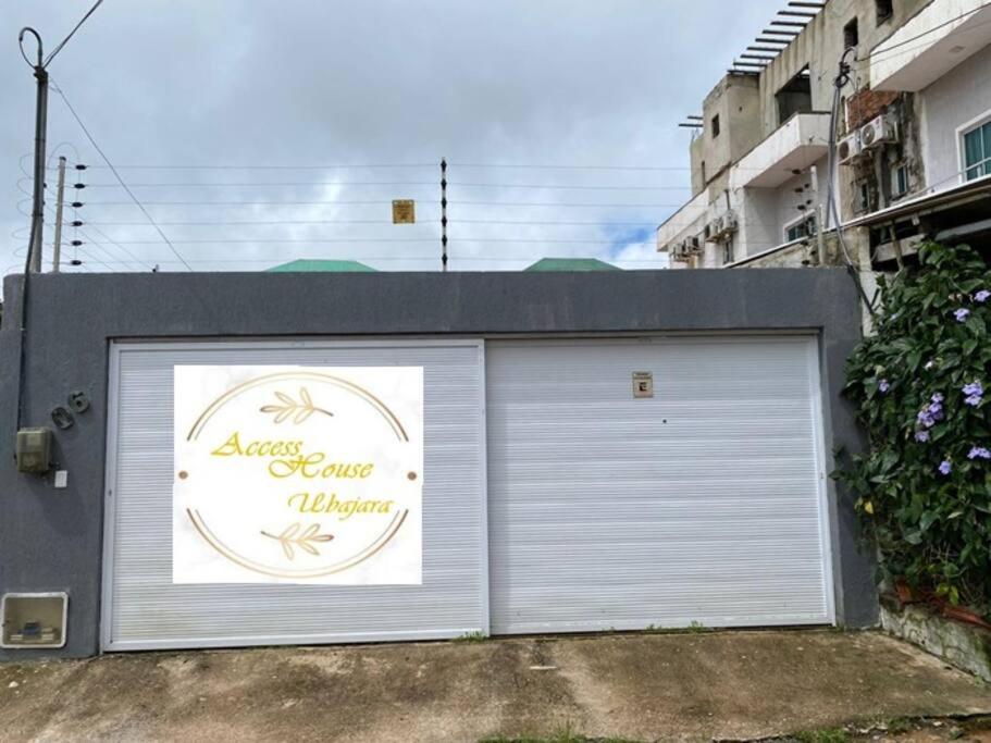 une porte de garage blanche avec un panneau sur celle-ci dans l'établissement Access House Ubajara:Sua casa na Serra Grande CE, à Ubajara