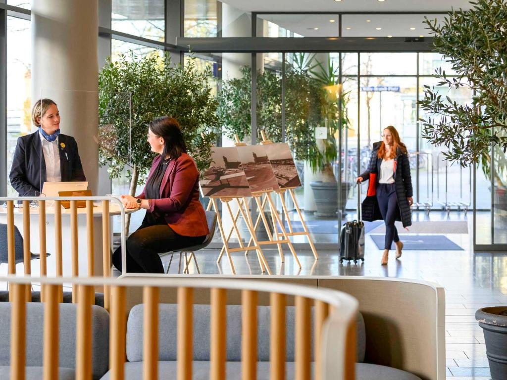 نوفوتيل ميونيخ ميسي في ميونخ: مجموعة من الناس يجلسون على الطاولات في المبنى