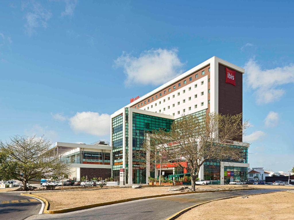 un gran edificio con un letrero rojo. en Ibis Cancun Centro en Cancún