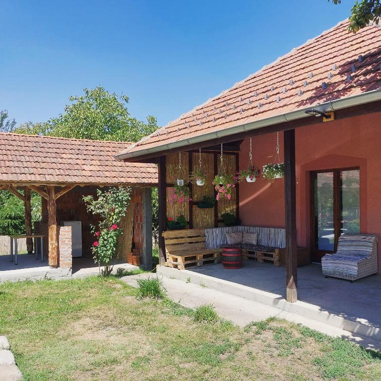 a patio of a house with a bench and flowers at Vila Vida in Kruševac