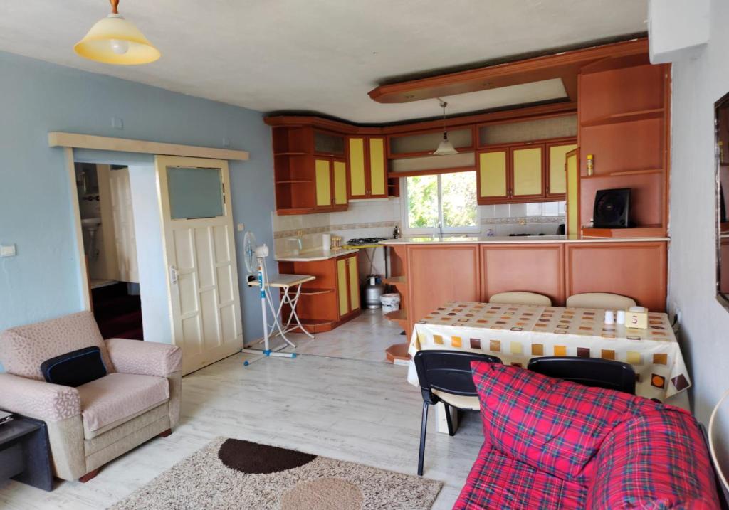 eine Küche und ein Wohnzimmer mit einem Tisch und Stühlen in der Unterkunft village house in Burunabat